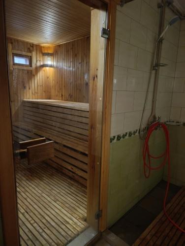 a bathroom with a tub with a shower in it at Гостьовий будинок з банею in Bohuslav