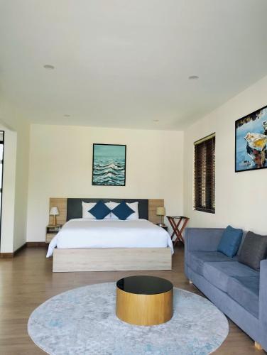 a bedroom with a bed and a couch at Bin Bin Coastar Villa Hồ Tràm in Ho Tram