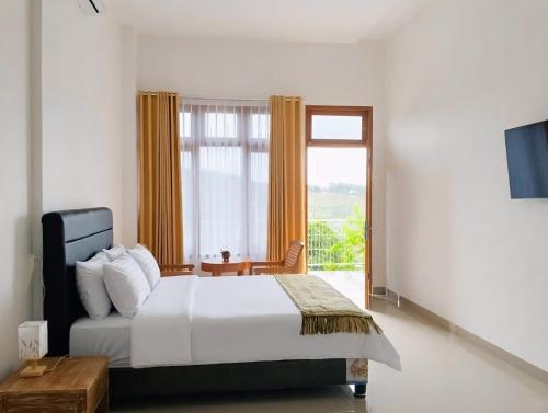 a bedroom with a bed and a large window at Arirang Sea View Homestay in Senggigi