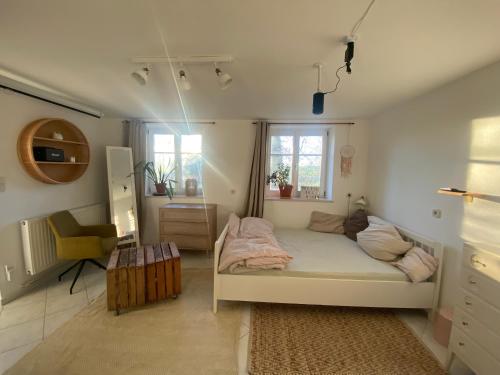 a small bedroom with a bed and a chair at Souterrainwohnung mit Badesteg an der Paar in Friedberg