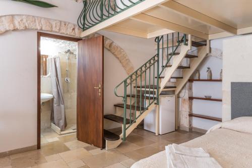 a bedroom with a spiral staircase and a bathroom at White Stone Flats & Studios in Ostuni