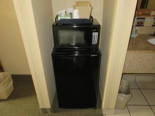 a microwave on top of a refrigerator in a room at La Hacienda Inn near Alamodome & Riverwalk in San Antonio