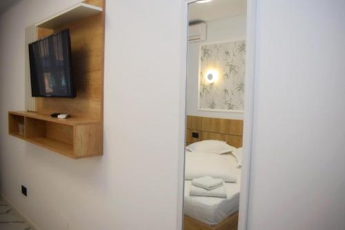a small room with a bed and a television at Pensiunea Duet in Sărata-Monteoru