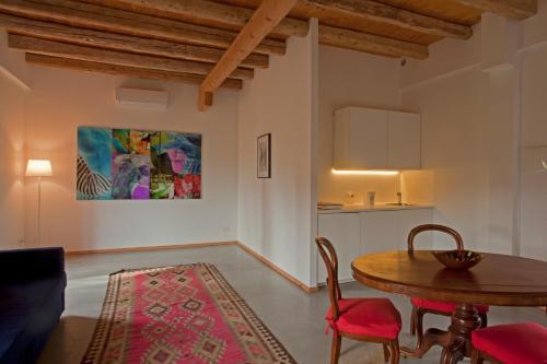 a living room with a table and chairs and a kitchen at Casa Adami Due in Brussa