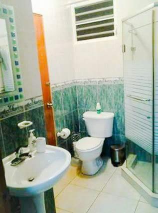 a bathroom with a toilet and a sink at Family Guest House in Quebradillas