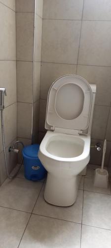 a bathroom with a toilet and a blue bucket at Paran Amboseli Resort in Kimana