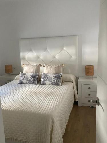 a bedroom with a large bed with a white bedspread at Center Luxury Chalet Mazagón in Mazagón
