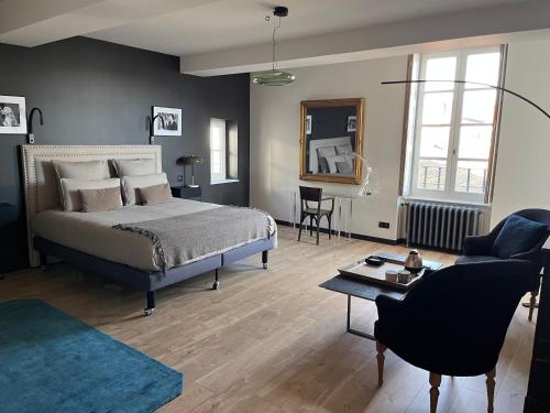 una camera da letto con un letto e un soggiorno di L'Hotel Particulier a Louhans