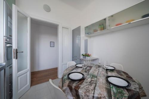 a dining room with a wooden table and white chairs at Station 1 min - Monza Center, Milan - Wifi and AC in Monza