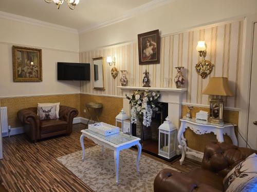 a living room with a couch and a fireplace at The Old Tramhouse Self Catering Traditional Charming Apartments Located In The Heart Of Historic Stirling For Short-Long Stays In Stirling For Tourism & Events & Contractor Base Stays For Central Belt Area & Open To Book All Year Round in Stirling
