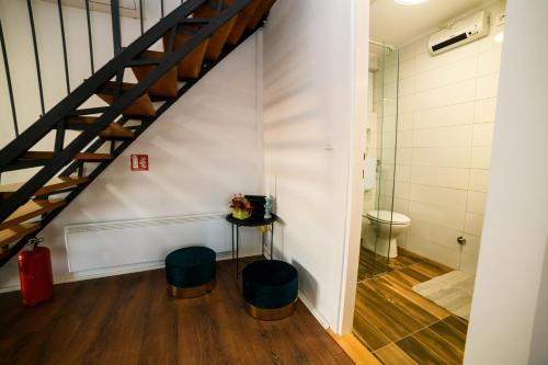 a bathroom with a toilet and a table and stools at Kuća za odmor Aria in Krapina