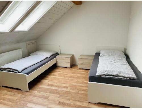 zwei Betten in einem Zimmer mit Fenster in der Unterkunft Dachstudio Eggingen in Eggingen