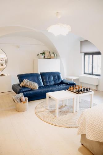 a living room with a blue couch and chessboard on a table at Brána historic Boutique Apartments in Horažďovice