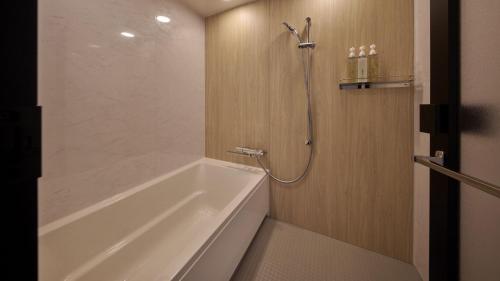a bathroom with a white tub and a shower at The Royal Park Hotel Maihama Resort Tokyo Bay in Urayasu
