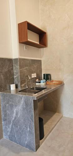 a kitchen with a sink and a counter top at Jepun Segara Guest House in Kuta