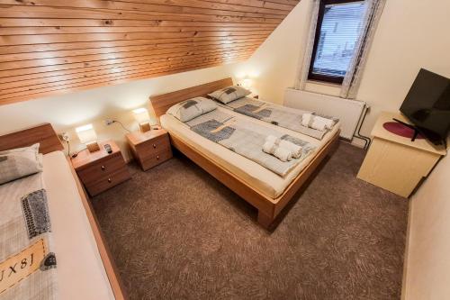 a bedroom with a large bed with a wooden ceiling at Apartma Horvat in Bohinj