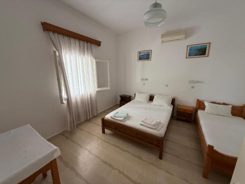 a small room with two beds and a window at Helena & Giorgio Rooms Cfu in Agios Georgios
