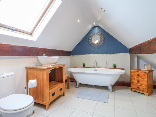 a bathroom with a tub and a toilet and a sink at Scamnel in Stafford