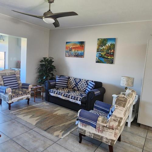 a living room with a couch and two chairs at Dolfyn201 La Mer in Hartenbos