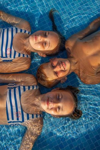 a group of people in a swimming pool at Gloria Apartments in Caesar Blue Resort,Gym, Swimming Pools, Sauna, Hammam, Kids' club available in Perivolia tou Trikomou
