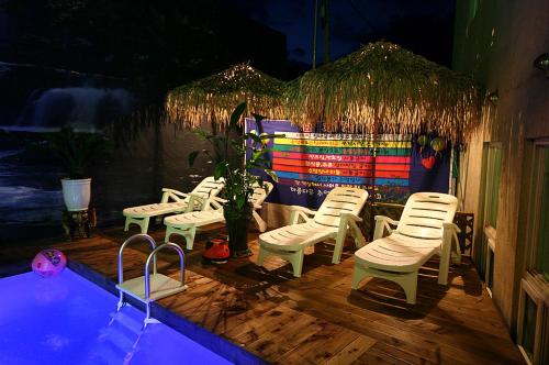 a group of chairs sitting next to a swimming pool at Gangchon Beautiful Pension in Chuncheon