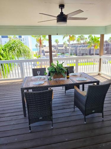a table and chairs on a deck with a ceiling fan at 126 E Pike home in South Padre Island