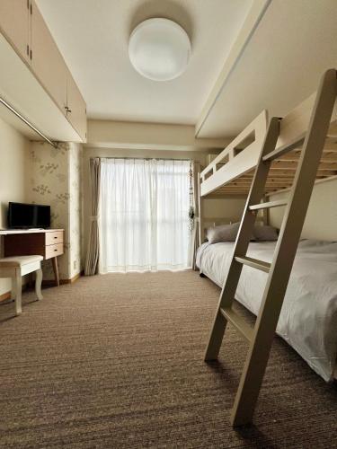 ein Schlafzimmer mit einem Etagenbett und einem Schreibtisch in der Unterkunft Hanazono501 in Niigata