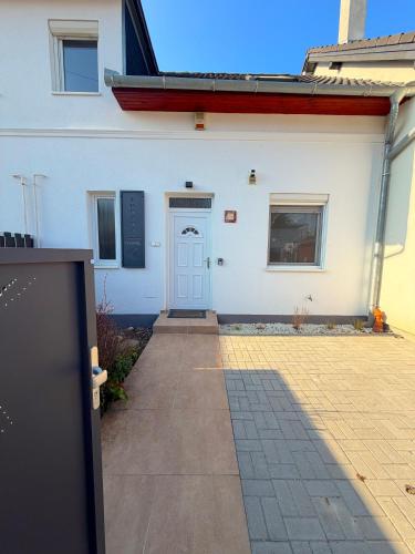 a white building with a blue door on it at Aurora Premium Home in Győr