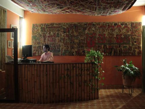 a man sitting at a reception desk in a lobby at Boutique Hotel Maharaja in Granada