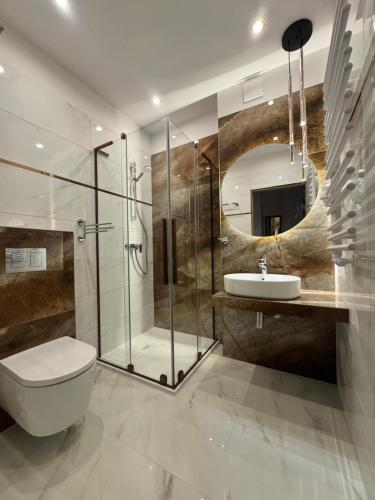 a bathroom with a shower and a toilet and a sink at Promes Mielno, Centrum, Kryty Basen, Sauna in Mielno