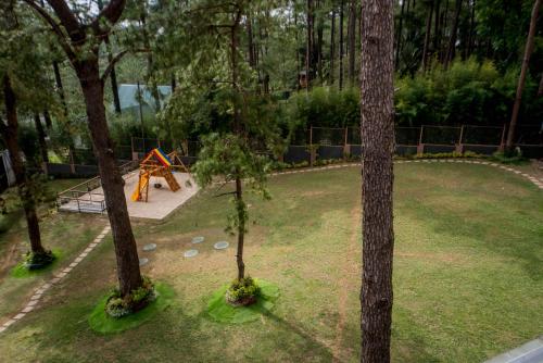 a park with a playground with trees and a play implement at Grand Sierra Pines Baguio in Baguio