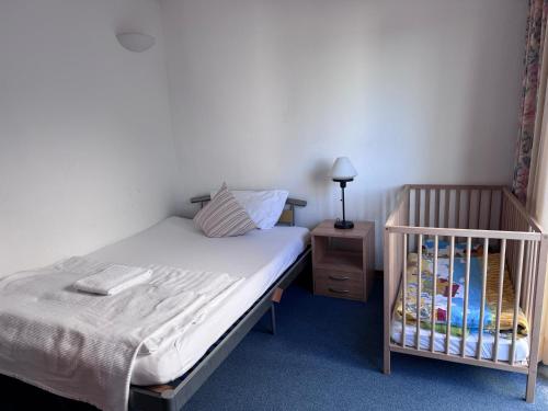 a bed with a crib in a bedroom at Hotel Torgauer Brauhof in Torgau