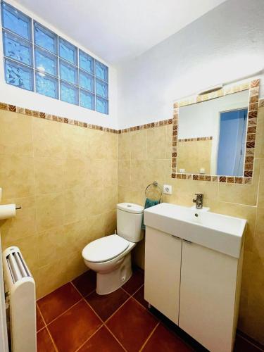 a bathroom with a toilet and a sink and a mirror at Apartamento Ada a 2 minutos de la playa y con piscina! in Arenal d'en Castell