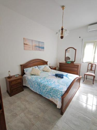 a bedroom with a bed and a mirror and a chair at Su Muscadeddu in Tertenìa