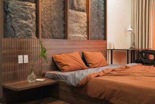 a bedroom with a bed and a vase on a table at Healing Home - Charm Ruby Apartment in Dĩ An