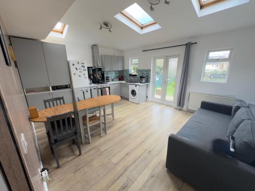 a kitchen and living room with a table and a couch at Sunny in London