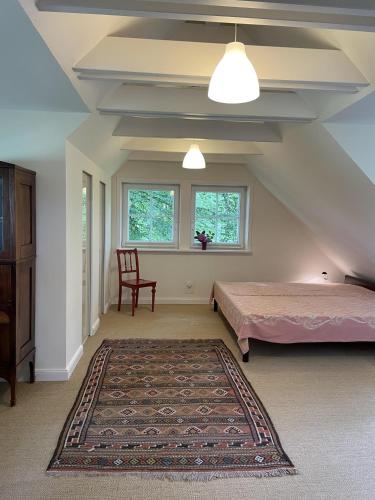 a attic bedroom with a bed and a chair at Heidenest in Soltau