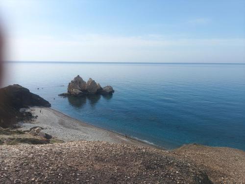 a beach with some rocks in the water at Nice relaxing apartment in Mandria, in Mandria