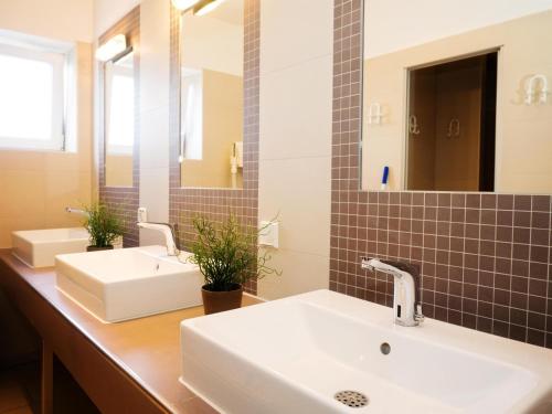 a bathroom with two sinks and a mirror at Ostseeferienpark Walkyrien in Schashagen