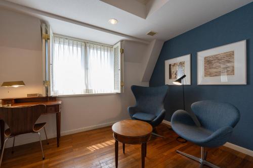 a room with two chairs and a desk and a lamp at Setre Glover's House Nagasaki in Nagasaki