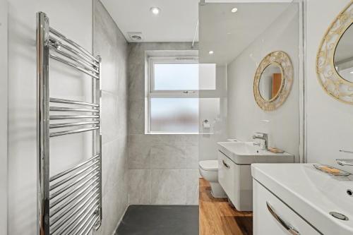 a bathroom with a shower and a toilet and a sink at Finest Retreats - Twickers Townhouse in Whitton