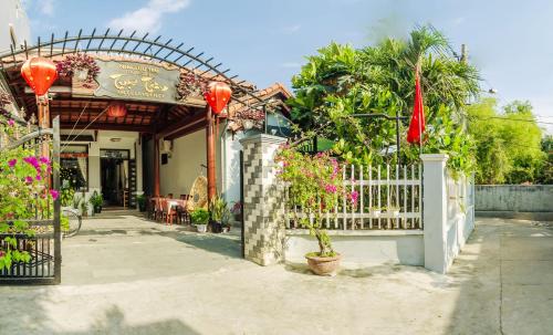 a house with a white fence and a gate at Tue Tam Garden Villa in Hoi An