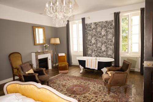 a living room with a fireplace and a chandelier at Domaine de charme pour groupes et evenement in Chillac