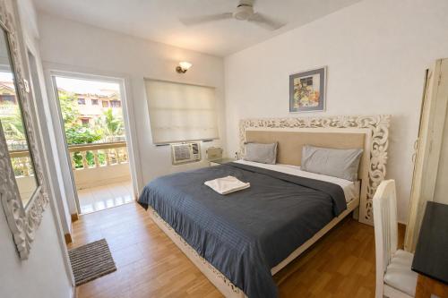 a bedroom with a bed in a room with a window at Lilly candolim apartment in Candolim