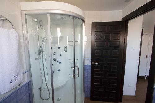 a bathroom with a shower and a glass door at La iaia Merce in L'Aldea