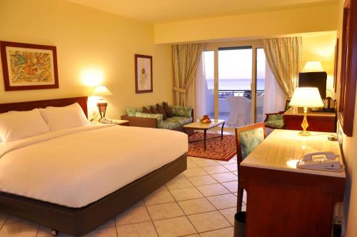 a hotel room with a bed and a living room at Safir Sharm Waterfalls Resort in Sharm El Sheikh