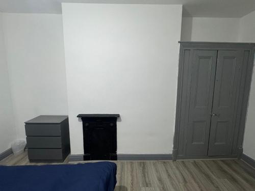 a bedroom with a bed and a dresser and a door at Modern Apartment Bradford City Centre Self Check In in Bradford