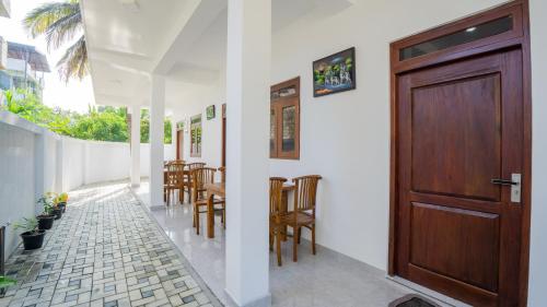a room with a wooden door and a table and chairs at Near Town Lodge in Dambulla