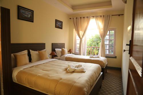 2 letti in una camera d'albergo con finestra di Bed and Breakfast Thamel a Kathmandu