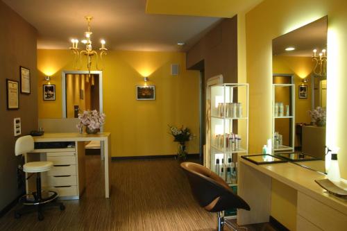 a yellow room with a desk and a mirror at Hotel Greif in Lignano Sabbiadoro